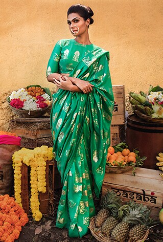 Green silk saree featuring foil print paired with a similar green blouse.