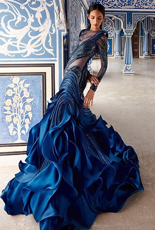 The voluminous blue gown features intricate glass beads embroidered on sheer tulle.