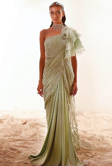 Featuring a nile green draped saree in crepe satin, assam silk, organza, and bamber silk base with hand embroidery.