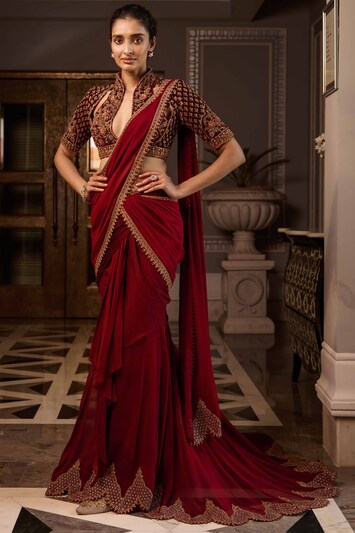 Featuring a red pre-stitched draped chiffon saree with embroidery. It is paired with a matching velvet cutout blouse.