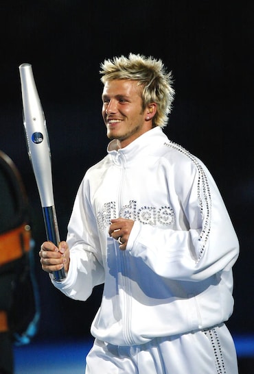 England National football captain David Beckham smiles as he and Kirsty Howard carry the Queens Jubille baton on it's final leg around the city of Manchester stadium ahead of the opening ceremony of the Commonwealth Games.