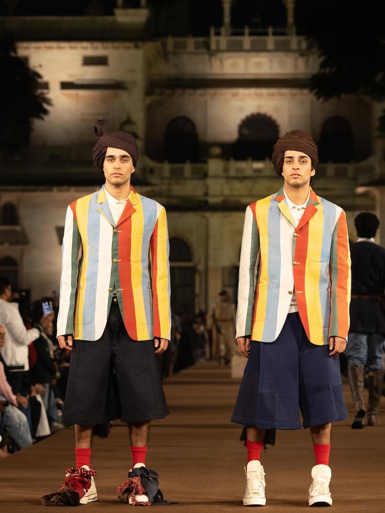 Runway procession styled like the school’s iconic march-past, accompanied by a live brass band